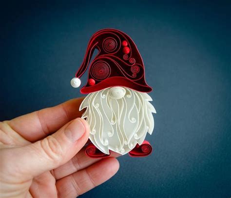 A Hand Holding An Ornament Shaped Like A Gnome