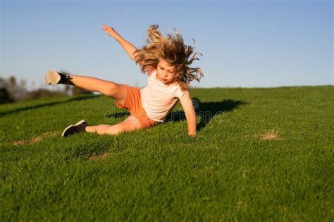 Kid Runs Through The Spring Grass And Falling Down On The Ground In