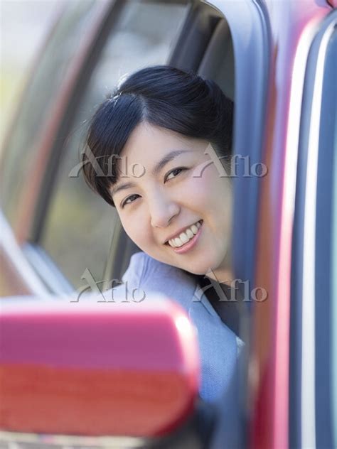 車の窓から顔を出す日本人女性 30573268 の写真素材 アフロ