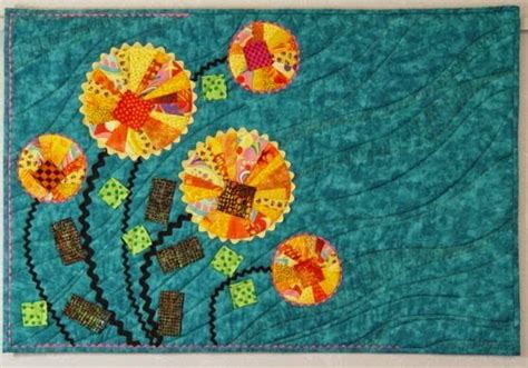 A Quilted Wall Hanging With Colorful Flowers On It S Sides And Blue