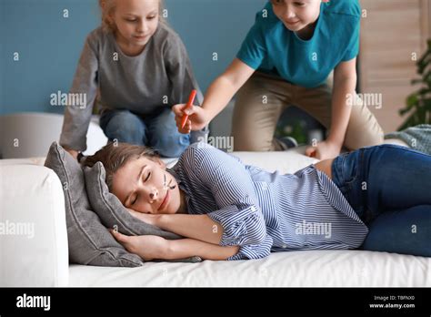 Little children drawing on face of their sleeping mother. April fools' day prank Stock Photo - Alamy