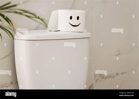 Roll of paper with funny face on toilet bowl in bathroom Stock Photo ...