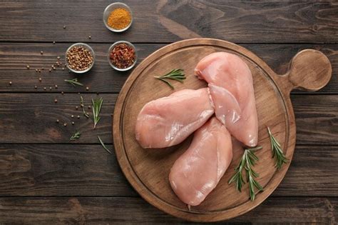 Premium Photo Board With Raw Chicken Fillet On Wooden Background