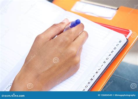 Female Hand Holding Pen And Writing In Book Stock Image Image Of