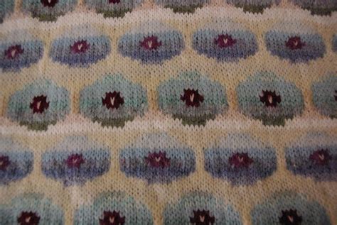 A Crocheted Blanket With Flowers On It Is Shown In Close Up View From The Bottom