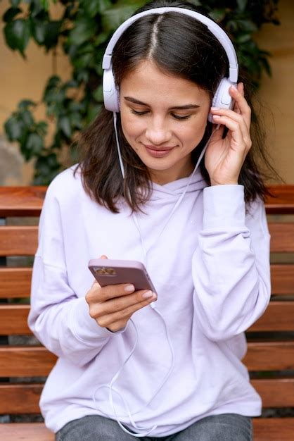 Mulher em tiro médio usando fones de ouvido Foto Grátis