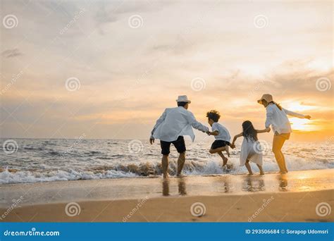 La Familia Feliz Se Divierte Saltando A La Playa En Vacaciones Al