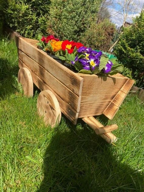 A Wooden Wheelbarrow With Flowers In It