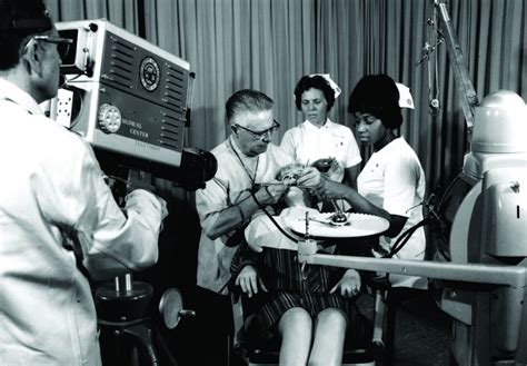 A Black And White Photo Of People In An Operating Room Looking At