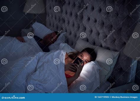 Mulher Mora Na Cama Verificando Telefone Celular Enquanto O Homem Dorme