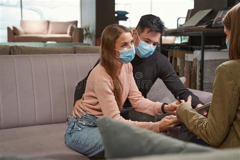 Two Shoppers In Face Masks Setting Signature To Document Stock Image