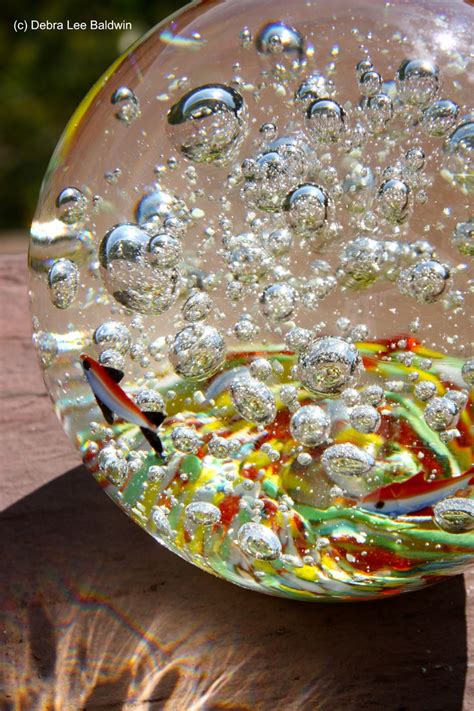 A Glass Bowl Sitting On Top Of A Wooden Table Covered In Bubbles And