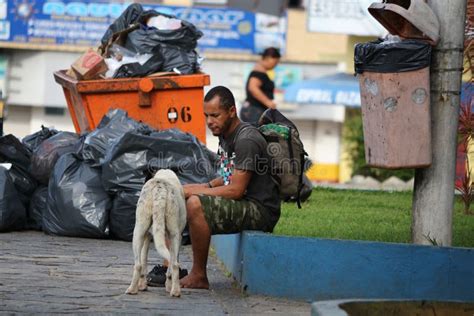 Morador Da Rua De Brasil Assentado Ao Lado Dos Sacos Do Balde Do Lixo E