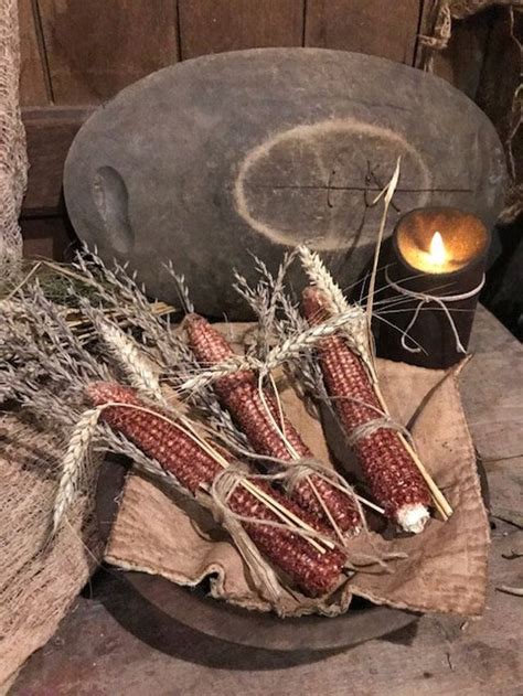 Corn On The Cob In Front Of An Old Stone Pot With A Lit Candle