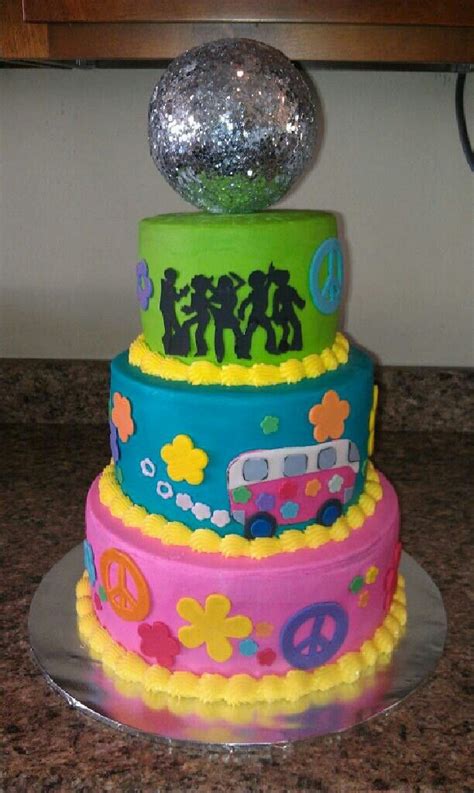 A Multi Tiered Cake Decorated With Peace Signs And Hippies On Top