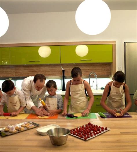 A Group Of People In Aprons Preparing Food On A Kitchen Counter With