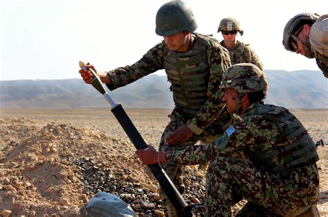 A Us Contractor Observes As An Afghan Soldier Prepares To Load A