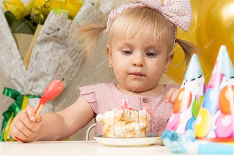 Premium Photo Twoyearold Blonde Girl Eating Birthday Cake On Her Birthday