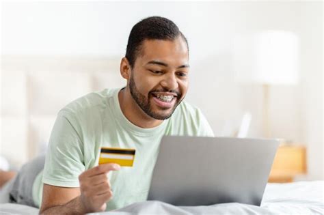 Premium Photo Relaxed African American Man Using Laptop And Credit Card