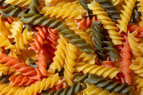 Premium Photo Uncooked Vibrant Colored Fusilli Pasta Background