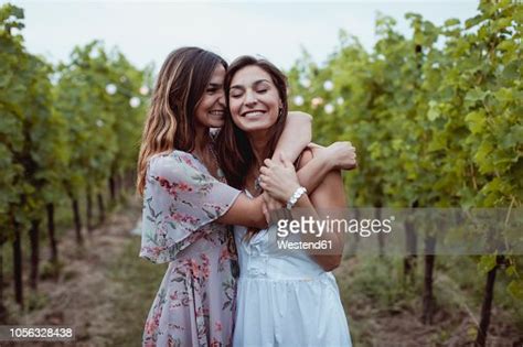 Twin Sisters Embracing At Summer Picnic In A Vineyard High Res Stock