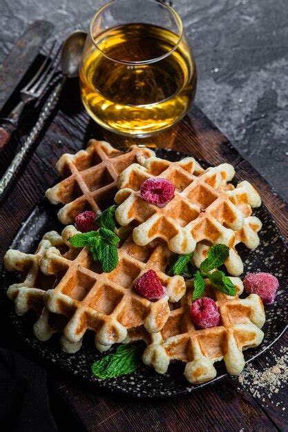 Waffles Belgas Con Frambuesas Y Menta En Un Plato Oscuro Foto Premium