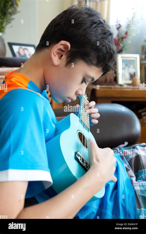 Young boy practicing on his ukulele Stock Photo - Alamy