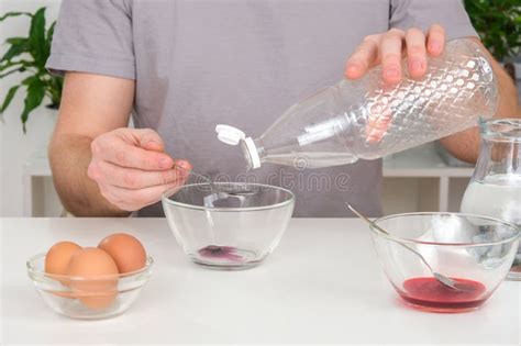 A Man Pours Spoonful Vinegar Into Glass Cup With Dye Dyeing Eggs With