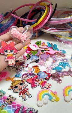 A Hand Holding A Heart Shaped Pin Surrounded By Lots Of Stickers And