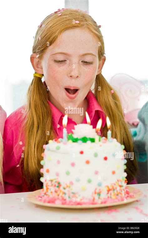 Girl Blowing Out Candles On A Birthday Cake Stock Photo Alamy