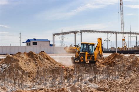 Escavadeira escava estacas terraplenagem para a construção da fundação