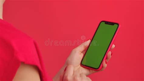 Woman Holds Mobile Phone With Green Workspace Mock Up Screen On Red