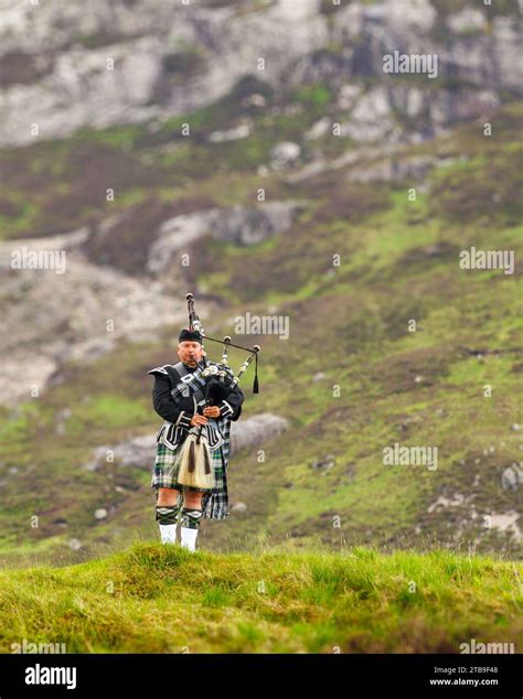 Scottish Bagpipe Player Playing In The Hills Of The Highlands In