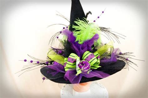 a woman wearing a black hat with purple and green decorations