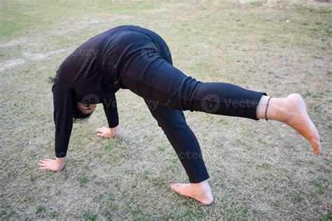 Young Indian woman practicing yoga outdoor in a park. Beautiful girl ...