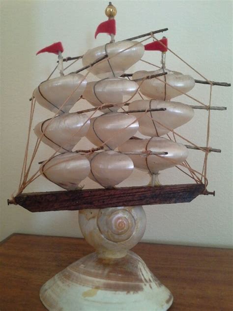 A Model Ship Made Out Of Shells On Top Of A Wooden Table