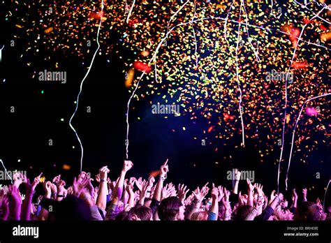 Crowd Of Young People Covered With Confetti During Rock Concert