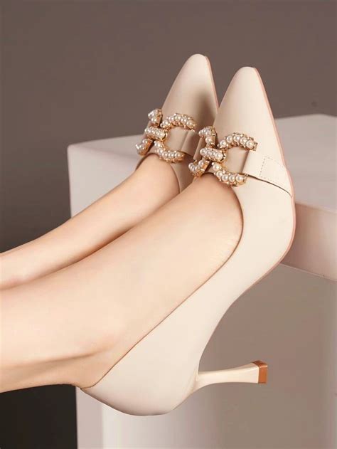 A Woman S Legs Wearing High Heels With Pearls On Them