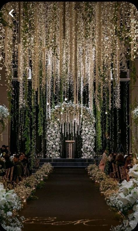 An Aisle Decorated With White Flowers And Greenery For A Wedding Or