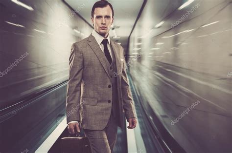 Man In Classic Grey Suit With Briefcase Standing On Escalator Stock