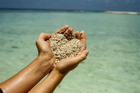 Sable En Forme De Coeur Chez Des Mains De La Femme Photo Stock Image