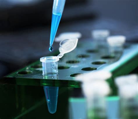 Scientist With Test Tubes And Flasks Conducting An Experiment In A