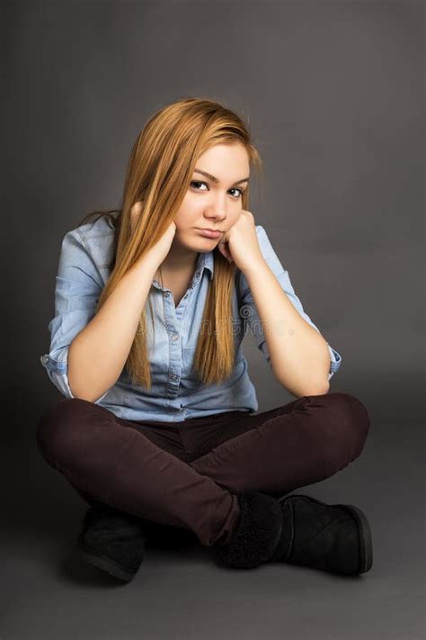 Adolescente Boudeuse S Asseyant Sur Le Plancher Avec Des Jambes