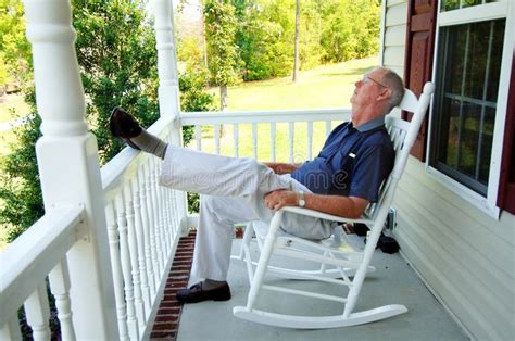 Senior Man Naps On Front Porch A Senior Man Asleep In A Rocking Chair