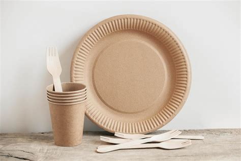 Wooden Forks And Paper Cups With Plates On Wooden Background