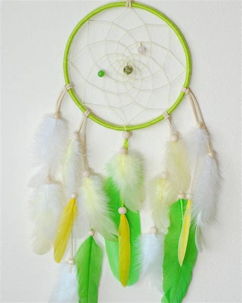 A Green And White Dream Catcher Hanging On The Wall