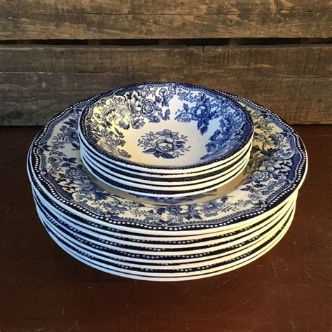 A Stack Of Blue And White Plates Sitting On Top Of A Wooden Table