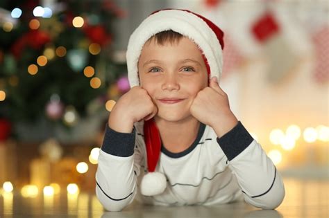 Niño feliz con gorro de papá noel en casa Foto Premium