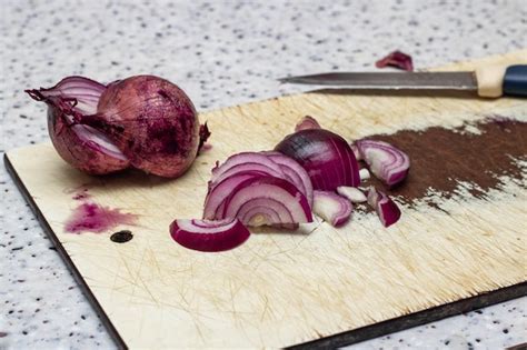 Rodajas De Cebollas Rojas En Una Tabla De Cocina De Madera Foto Premium