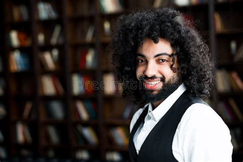 An African American Man With Curly Hair Smiling Broadly Standing In